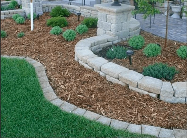 Edging photo showing clean stone borders around a mulched landscape bed.