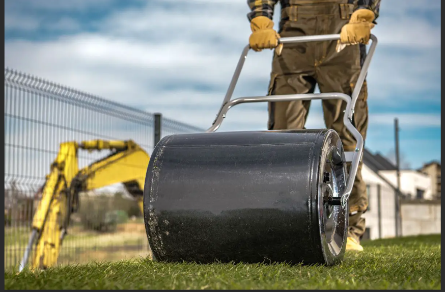 Yard rolling photo showing a lawn roller being pushed across grass.